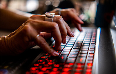 Female hand hacking on laptop